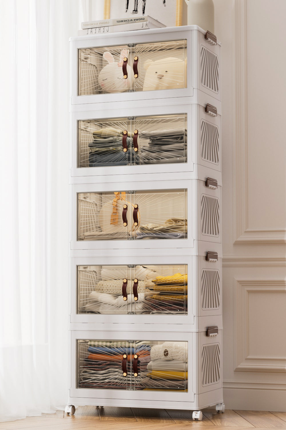 A five-tier, white Marcolo cabinet filled with folded clothes.