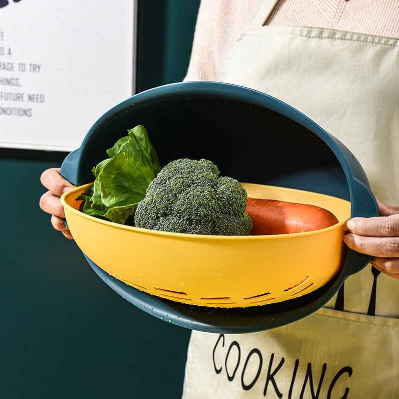 Hands holding Marcolo 2-in-1 colander bowl with vegetables.