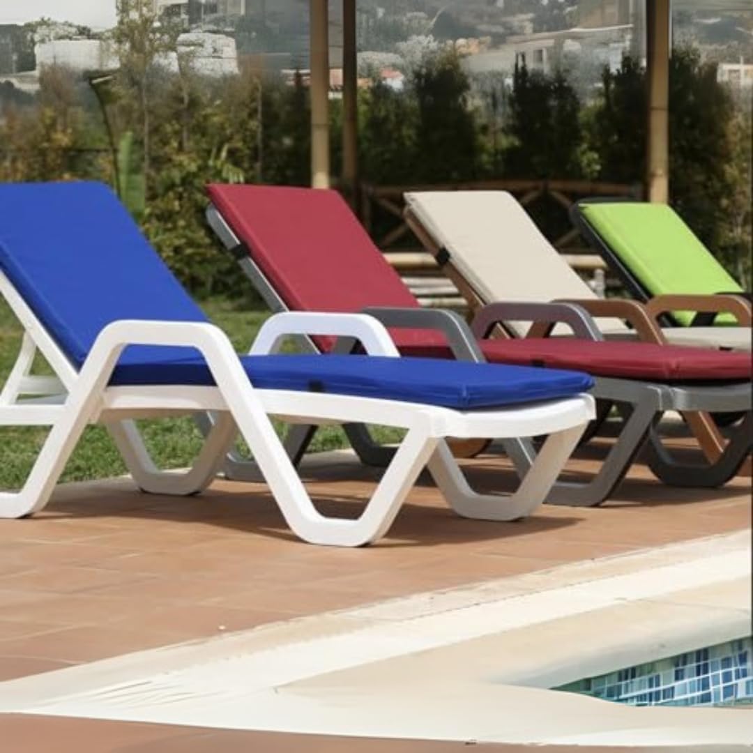 Marcolo adjustable plastic chaise lounges with colorful cushions by a pool.