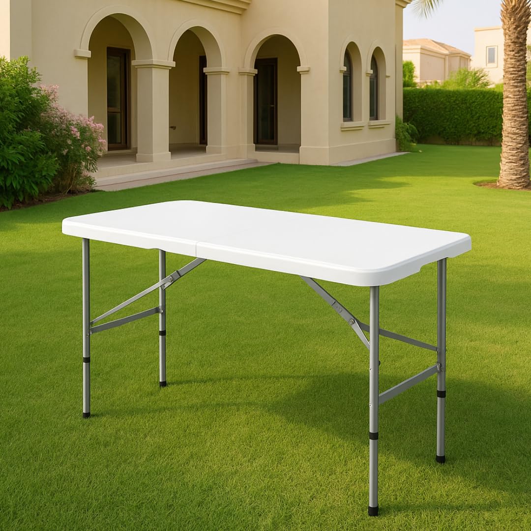 White plastic folding table with adjustable legs on grass.