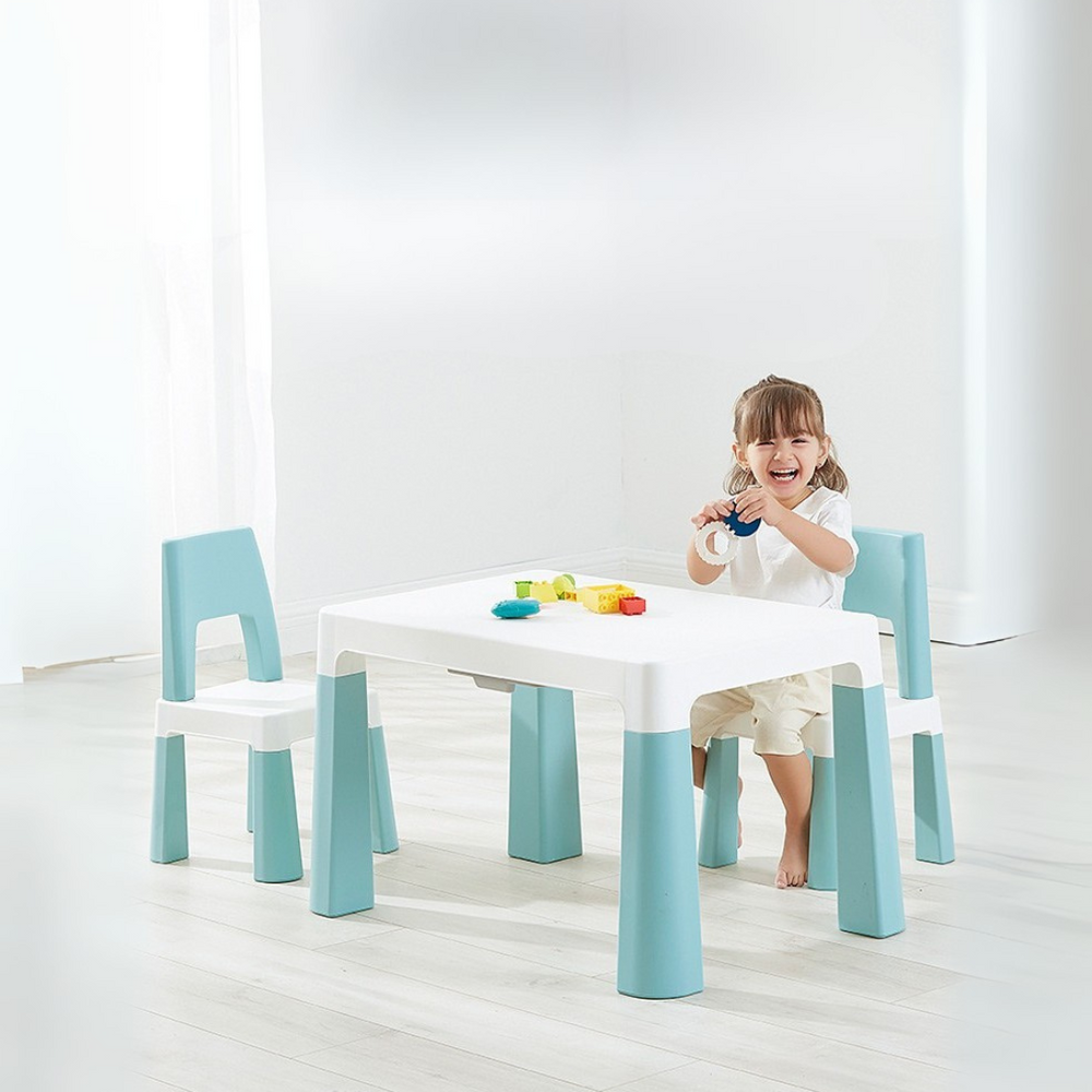 A toddler sitting at a Marcolo blue and white kids' table and chairs.