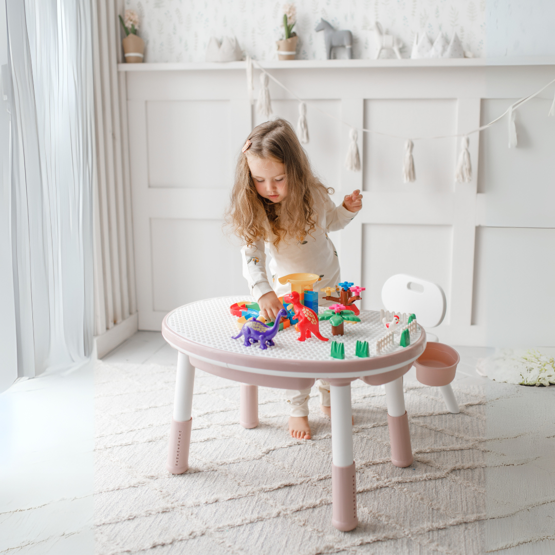 Marcolo child playing at a pink and white round table.