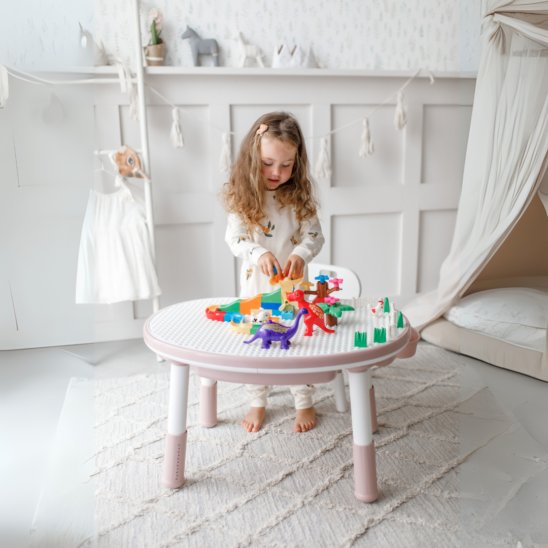 Girl playing with blocks and dinosaurs at a Marcolo kids table.