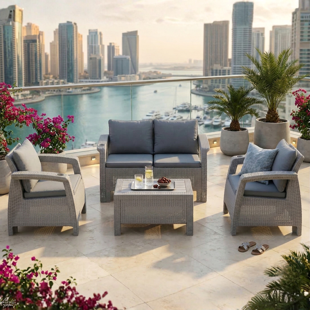 Marcolo wicker patio furniture set with grey cushions on a balcony overlooking the water.