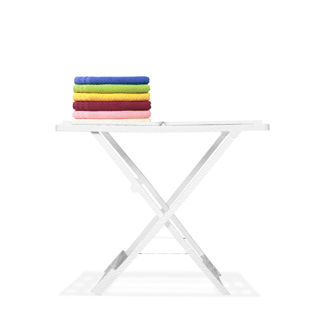 Marcolo white folding table with a stack of colored towels.