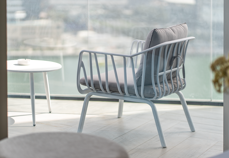 Marcolo white metal lounge chair with grey outdoor cushions.