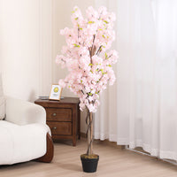 Marcolo pink artificial cherry blossom tree, 150 cm, standing in a living room beside a sofa and side table
