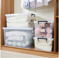 Clear Marcolo storage boxes filled with blankets and toys in a closet.