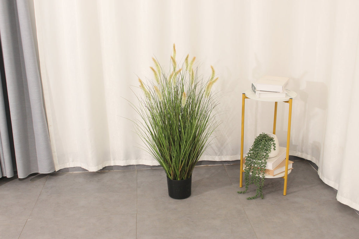 Marcolo 90 cm cream artificial grass plant in a room beside a side table