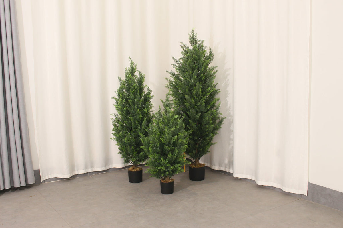 Marcolo 150 cm artificial pine tree shown with two other sizes in a room