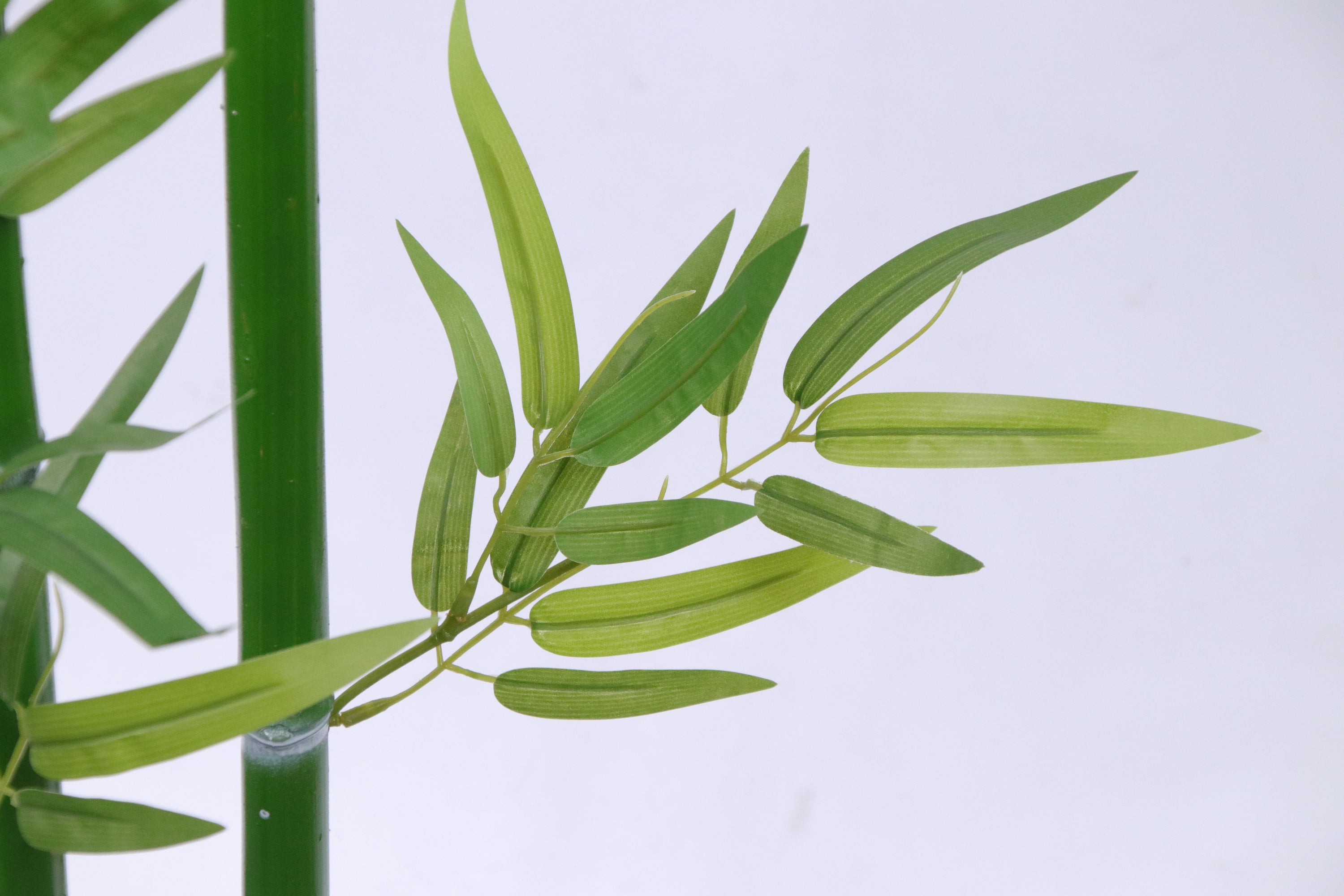 Marcolo artificial bamboo leaves with realistic long, narrow blades in a vibrant green hue.