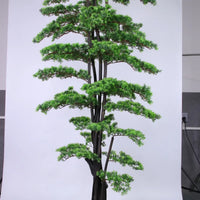 Marcolo artificial pine tree with lush green needles and a dark multi-stem trunk.