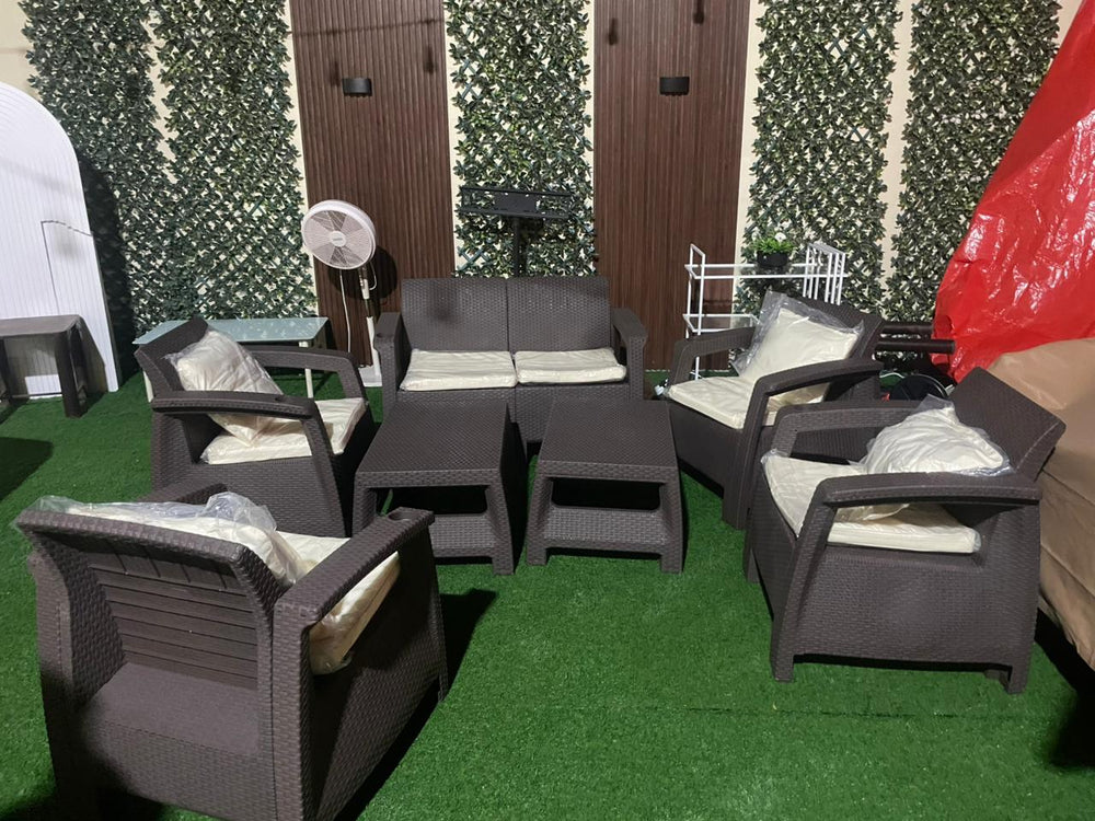 Customer's dark brown Havana rattan-look sofa sets on artificial grass in front of a green wall