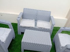 Grey Havana rattan-look loveseat and coffee table on artificial grass