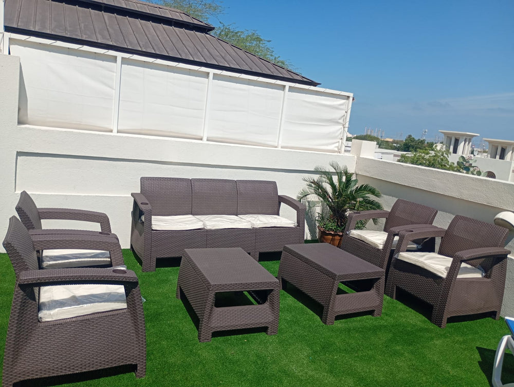 Customer's dark brown Havana rattan-look 7-seater sofa set with two tables on a sunny rooftop terrace