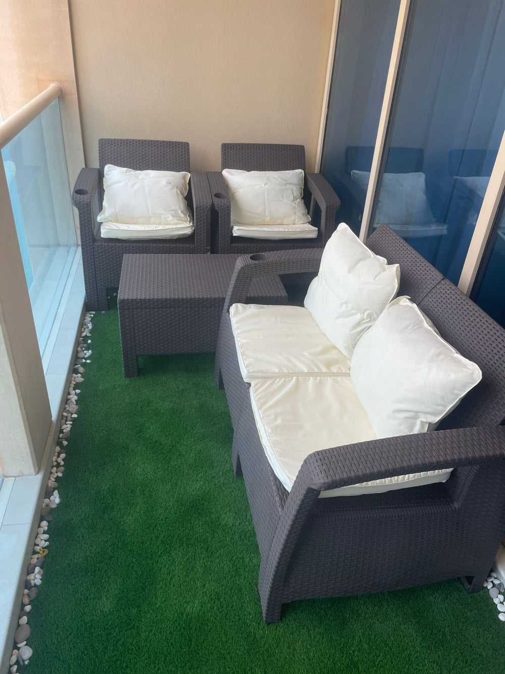 Customer's dark brown Havana rattan-look 4-seater sofa set with cream cushions on a balcony