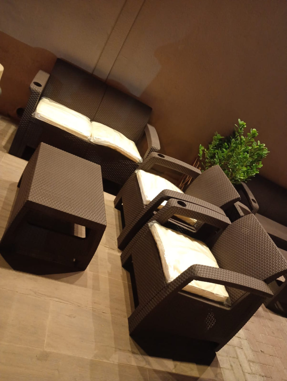 Dark brown Havana rattan-look armchairs and table with cream cushions, top view