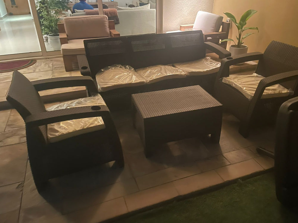 Customer's dark brown Havana rattan-look sofa set on a terrace in the evening