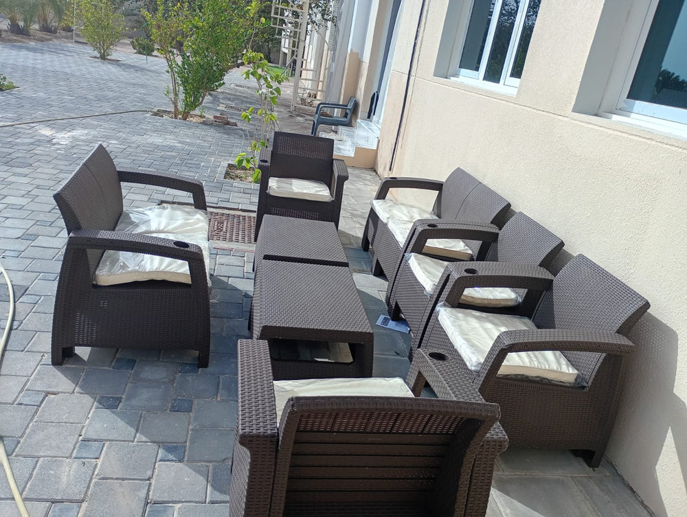 Several dark brown Havana rattan-look sofa sets in a customer's paved villa courtyard